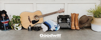 Collection of items including a bag, plants, vintage typewriter, cowboy boots, hat, and guitar.