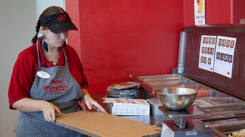 Employee of Papa Murphy's folding boxes.