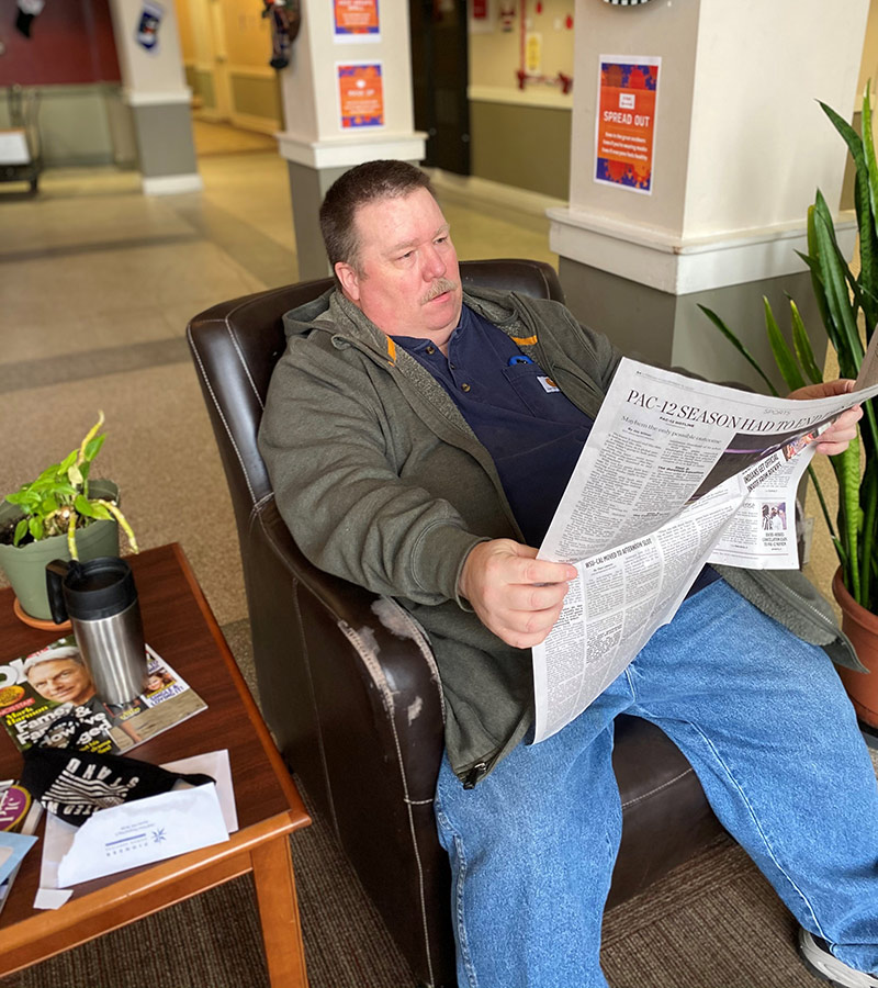 man relaxing and reading newspaper.