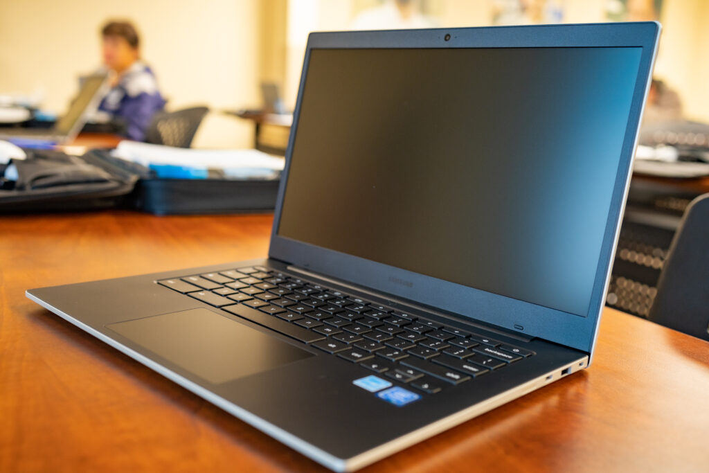 A Google Chromebook sits on a table with the screen black.