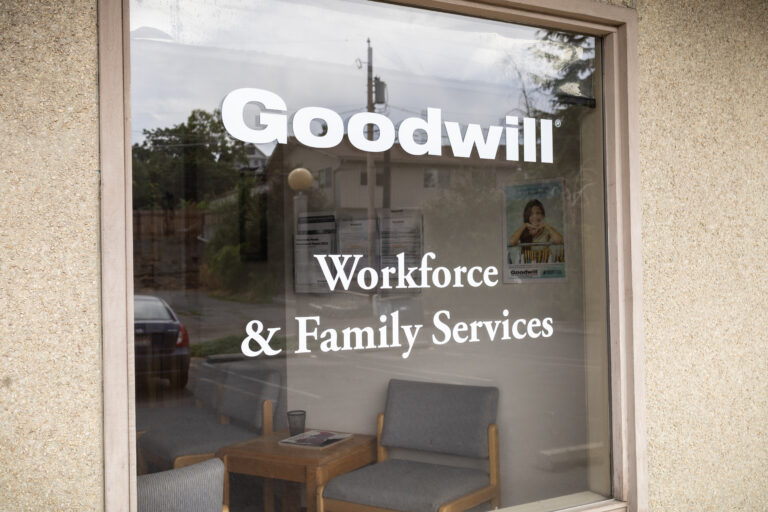 A glass door with the words "Goodwill Workforce & Family Services" in white.