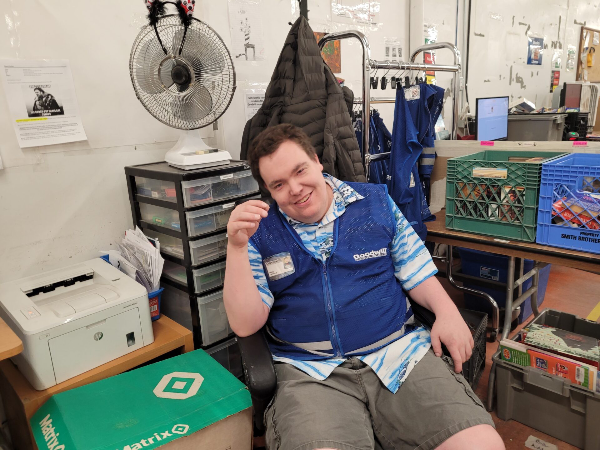 A man sitting at a workstation, smiling.
